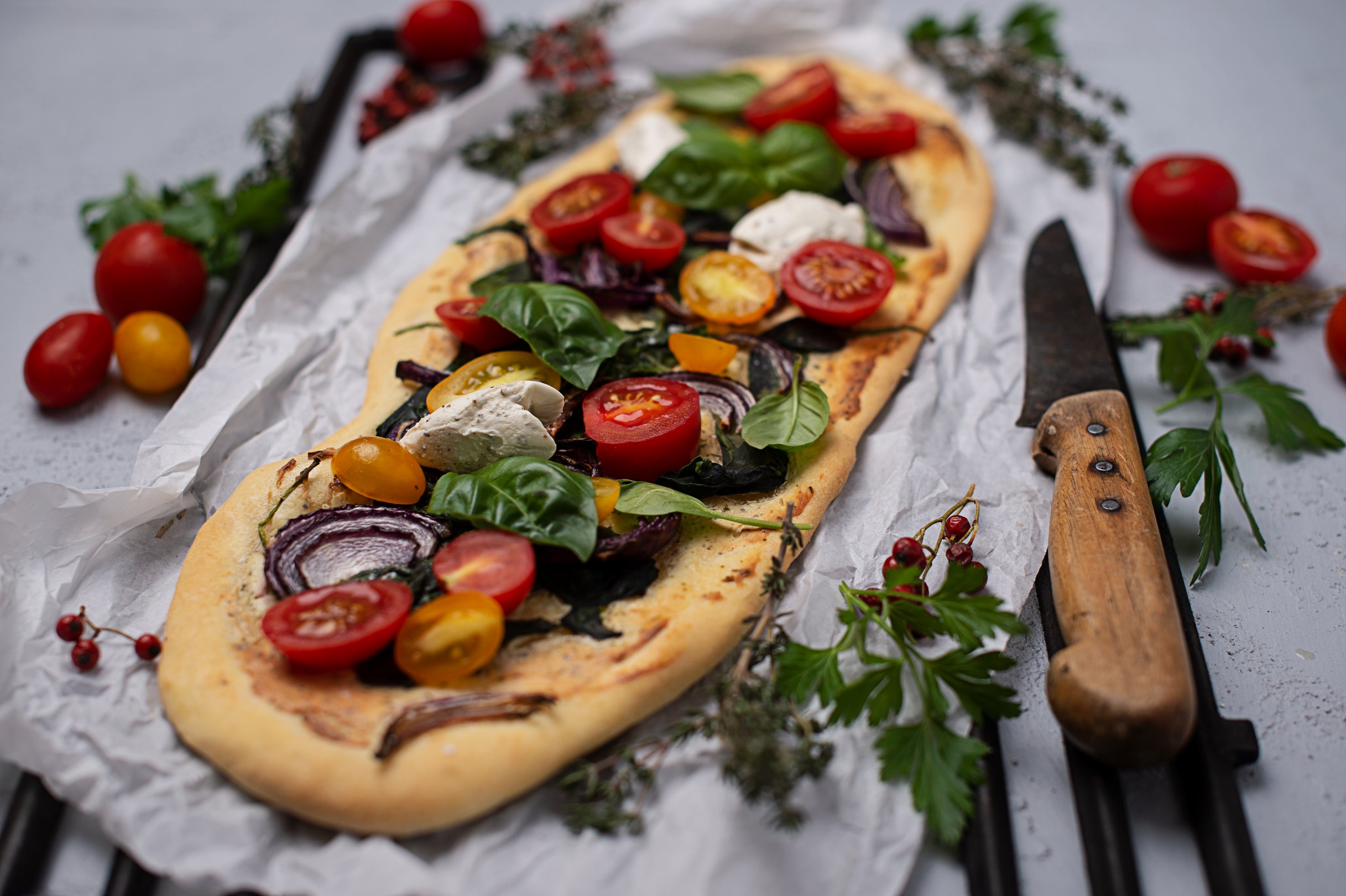Frischkäse-Flammkuchen mit Zwiebeln, Spinat und Rispentomaten