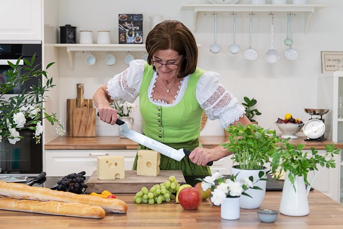 Frau schneidet Käse in der Küche