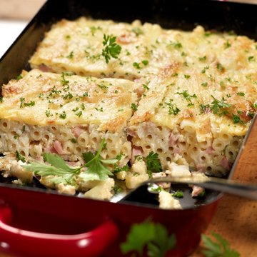 Frischer Nudel-Joghurt-Auflauf mit Schinken mit Petersilie verziert